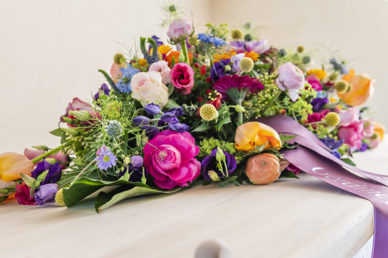 Rouwbloemen op kist