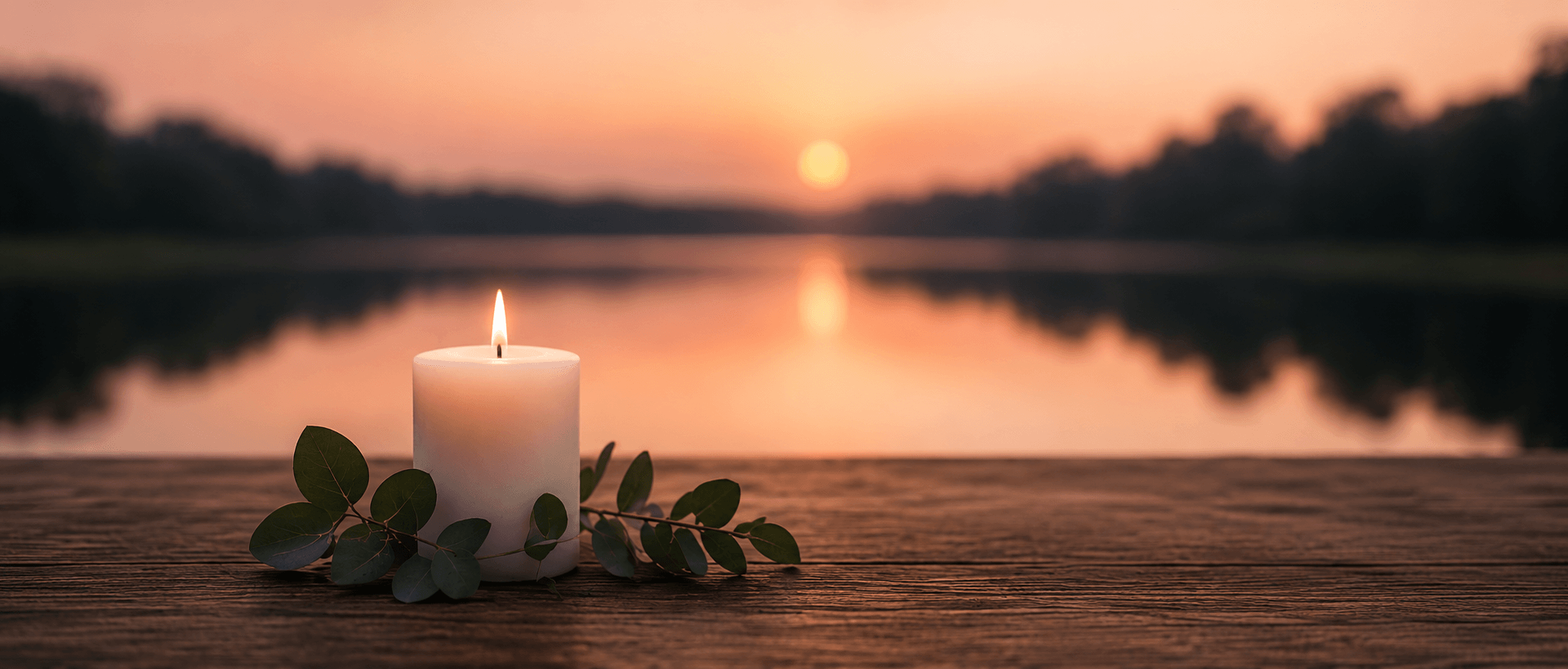 Kaars bij zonsondergang aan het water als symbool voor een stille crematie en herdenking